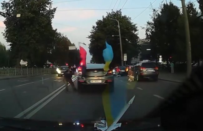 Чоловік у Рівному кинувся на колону «на Щиті» й зірвав патріотичний прапор (ВІДЕО)