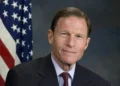 Будівля Капітолія США на тлі прапора