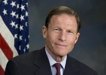 Будівля Капітолія США на тлі прапора