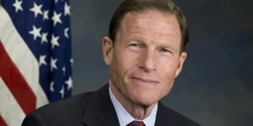 Будівля Капітолія США на тлі прапора