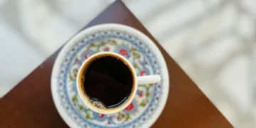 Чашка кави на столі поруч зі склянкою води