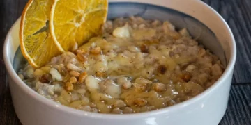 Порція готової вівсянки з фруктами на столі