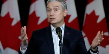 Прапори Канади та США на тлі торговельних контейнерів