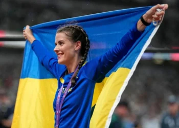 Стрибунка у висоту долає планку на стадіоні