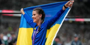 Стрибунка у висоту долає планку на стадіоні