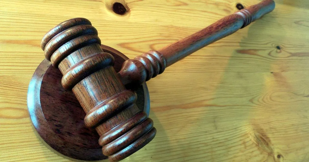 Будівля суду з судовим молотком на столі